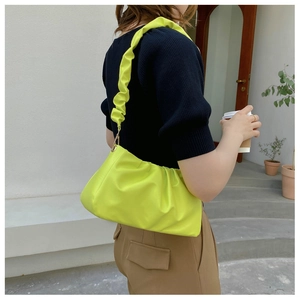 Fluorescent green ruched cloud bag with pleated shoulder strap shown on a model
