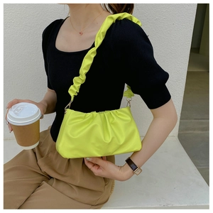 Detail of neon green cloud bag with soft pleated texture and gold metal buckle