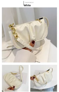 Detailed view of white pleated shoulder bag with gold chain and top zipper closure