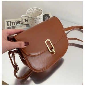 Detail der karamellbraunen Satteltasche mit minimalistischer goldener U-Metallschnalle