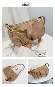 Detail of khaki pleated shoulder bag with gold chain strap and fine PU leather texture
