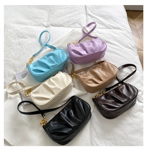 Detailed top view of pleated shoulder bags in six vibrant colors with gold chain straps