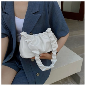 Detail of white pleated cloud bag with soft PU leather texture on a shoulder strap