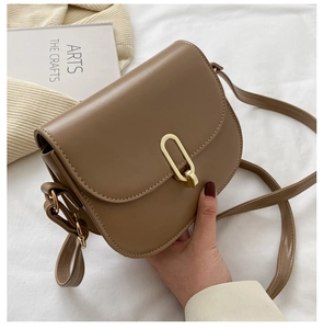 Detailaufnahme der braunen Satteltasche aus Leder mit goldener Schnalle und Textur