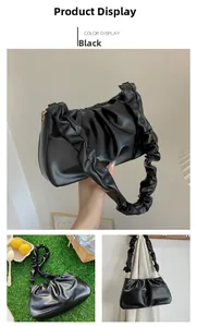 Detail of black pleated cloud bag with glossy faux leather finish and textured handle