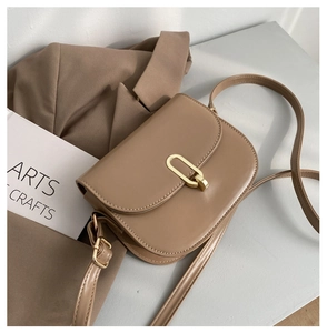 Makro-Detail der braunen Satteltasche aus Leder mit einer markanten goldenen Metallschnalle
