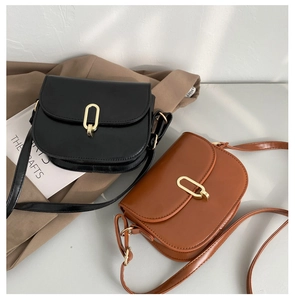 Draufsicht auf elegante Satteltaschen aus schwarzem und braunem Leder mit Goldbuckle