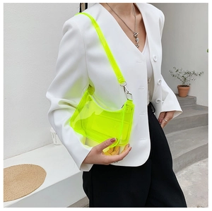 Neon yellow transparent PVC underarm bag styled with a minimalist white suit