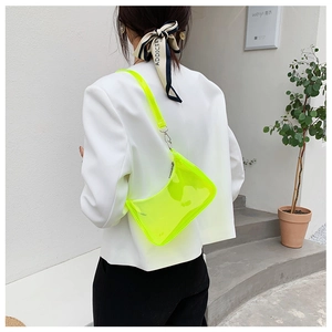 Neon green transparent jelly bag shown styled with a white blazer for a chic summer look