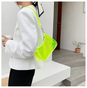 Neon green transparent PVC baguette bag styled with a white blazer on a model