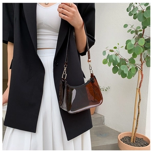 Detail of a brown translucent jelly shoulder bag styled with a minimalist outfit