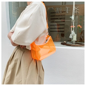 Close-up of orange transparent PVC jelly bag with silver zipper worn by a model
