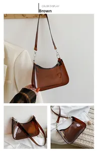 Detailed view of a brown transparent PVC crescent bag with silver hardware and zipper