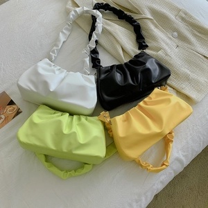 Minimalist ruched cloud bags in four colors with pleated straps on textured background