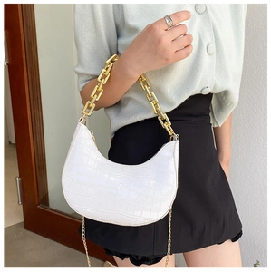 Detail of white crocodile pattern crescent bag with premium gold chunky chain handle