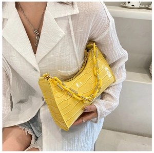 Detail of bright yellow faux crocodile skin bag with matching thick chain strap