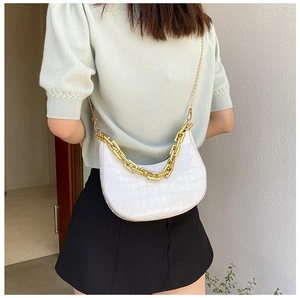 Detailed view of white crocodile pattern crescent bag with chunky gold chain strap
