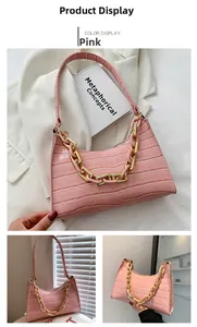 Detailed view of pink crocodile embossed shoulder bag with gold and pink chain strap
