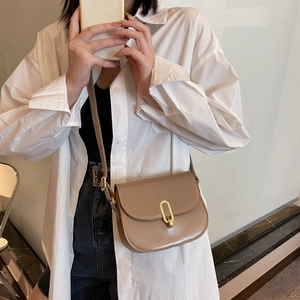 Schicke khakifarbene Satteltasche für Damen mit goldenem Verschluss im Freizeitlook