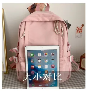 Pink student backpack with large capacity shown next to a tablet for size reference