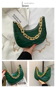 Close-up of green crocodile pattern crescent bag with chunky gold chain handle