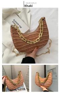Detail of khaki crescent bag with crocodile texture and chunky gold chain handle
