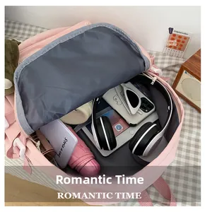 Internal capacity of light pink backpack showing tablet, headphones and umbrella