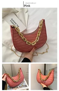 Detail of pink croc-embossed crescent bag with chunky gold chain and slim shoulder strap
