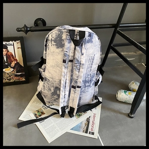 Détail du sac à dos imprimé journal tie-dye avec sangles latérales et poches