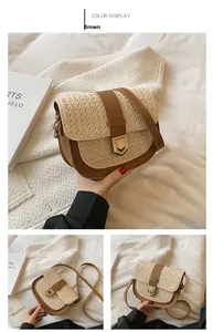 Details der gewebten Strohsatteltasche mit braunem Kunstlederbesatz und Goldverschluss