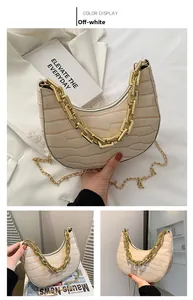 Detail of off-white crescent bag featuring crocodile texture and chunky gold chain strap