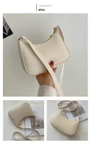 Detail view of white half-moon shoulder bag with fine texture and golden metal zipper
