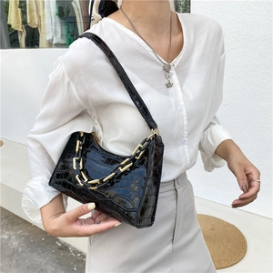 Classic black crocodile texture underarm bag with a bold gold chain handle detail