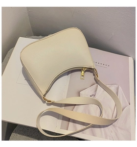 Detail of cream white half-moon shoulder bag with lychee grain PU leather and gold zipper