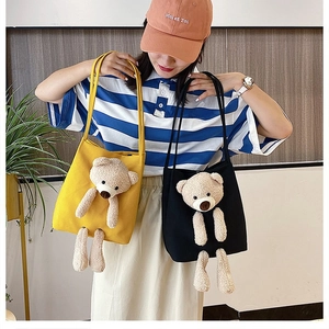Detail of canvas tote bag featuring a 3D plush bear decoration and stylish top handles