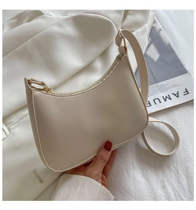 Detail of cream hobo shoulder bag with gold hardware and minimalist faux leather texture