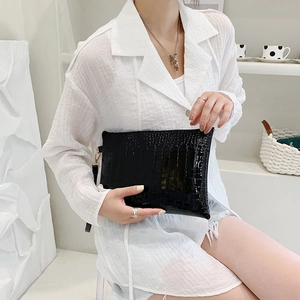 Elegante pochette nera in pelle coccodrillo con cinturino da polso e cerniera