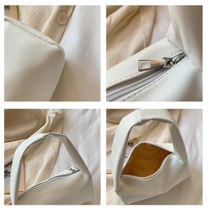 Detail of white PU leather cylinder bag showing zipper closure and soft textured handle