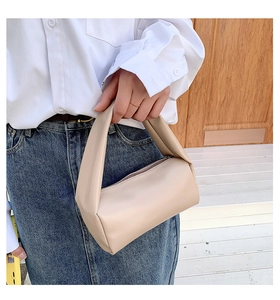 Minimalist beige cylinder handbag featuring soft PU leather and top zipper closure