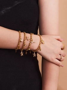Detailed close-up of golden ocean-themed bracelets with starfish, heart, and shell charms