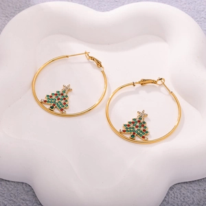 Detail of golden hoop earrings featuring a rhinestone Christmas tree charm in festive colors