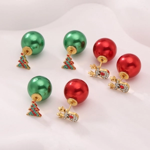 Detail of Christmas earrings featuring green trees and red reindeer with metal pearls