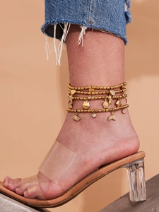 Detail of a four-layer gold beaded anklet with sea shell, turtle and whale tail charms