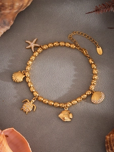 Detail of gold stainless steel ocean bracelet with starfish and shell charms and crystals