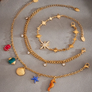 Bracelet de cheville en acier doré avec étoiles en zircon et breloques marines