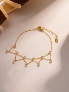 Détail du bracelet en acier inoxydable doré avec neuf gouttes de cristal étincelantes