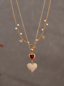 Dettaglio della collana a doppio strato placcata oro 18k con zircone rosso e pavé di cuori