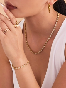 Détail d'une parure dorée avec collier en zircon et bague léopard scintillante pour femme