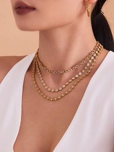 Détail du collier superposé avec pendentifs infini et cœur sertis de cristaux
