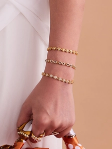 Détail de l'ensemble bracelets et bague dorés à l'infini avec des pierres de zircon